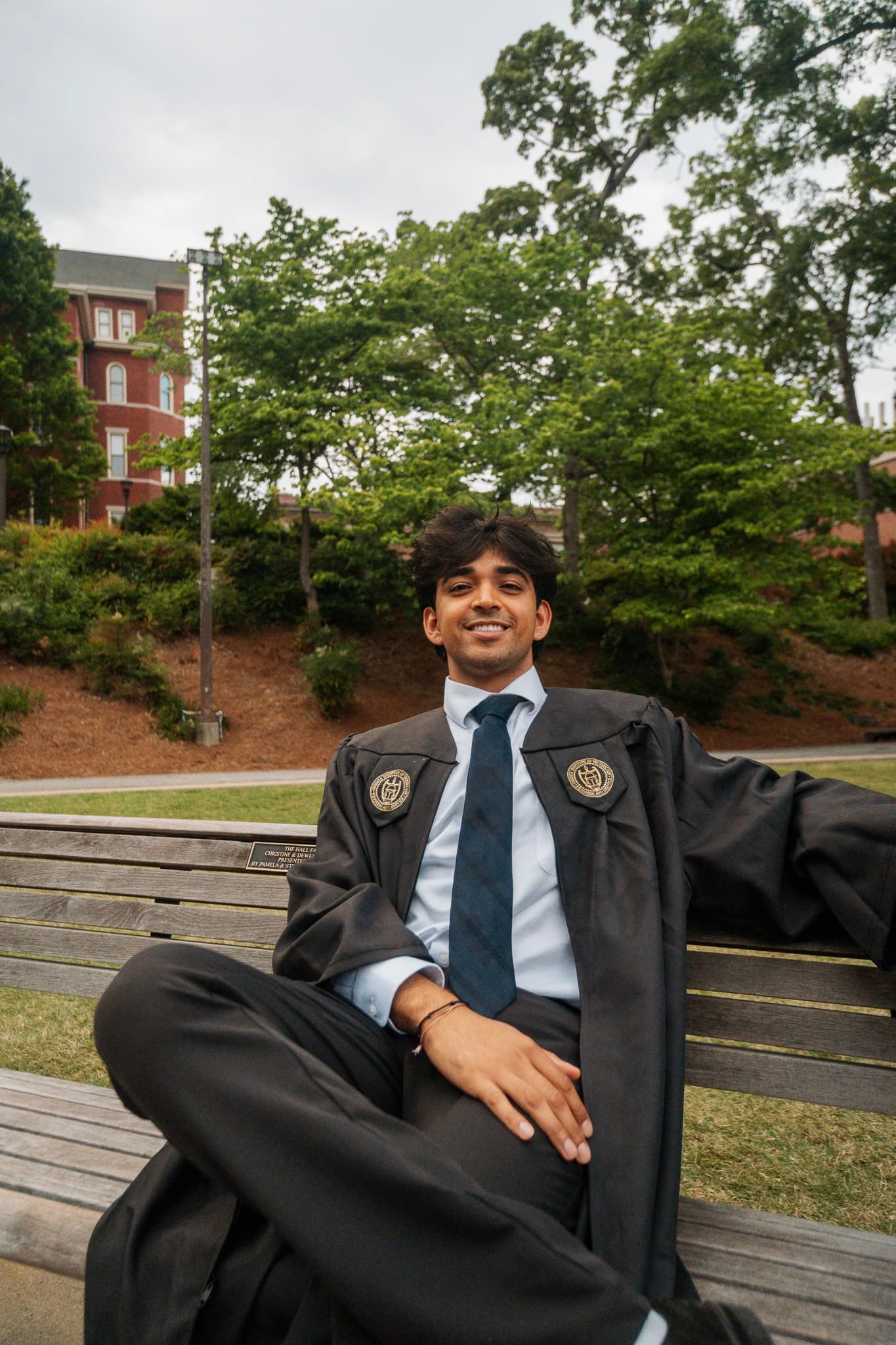 Sitting on a bench in cap and gown at Georgia Tech graduation